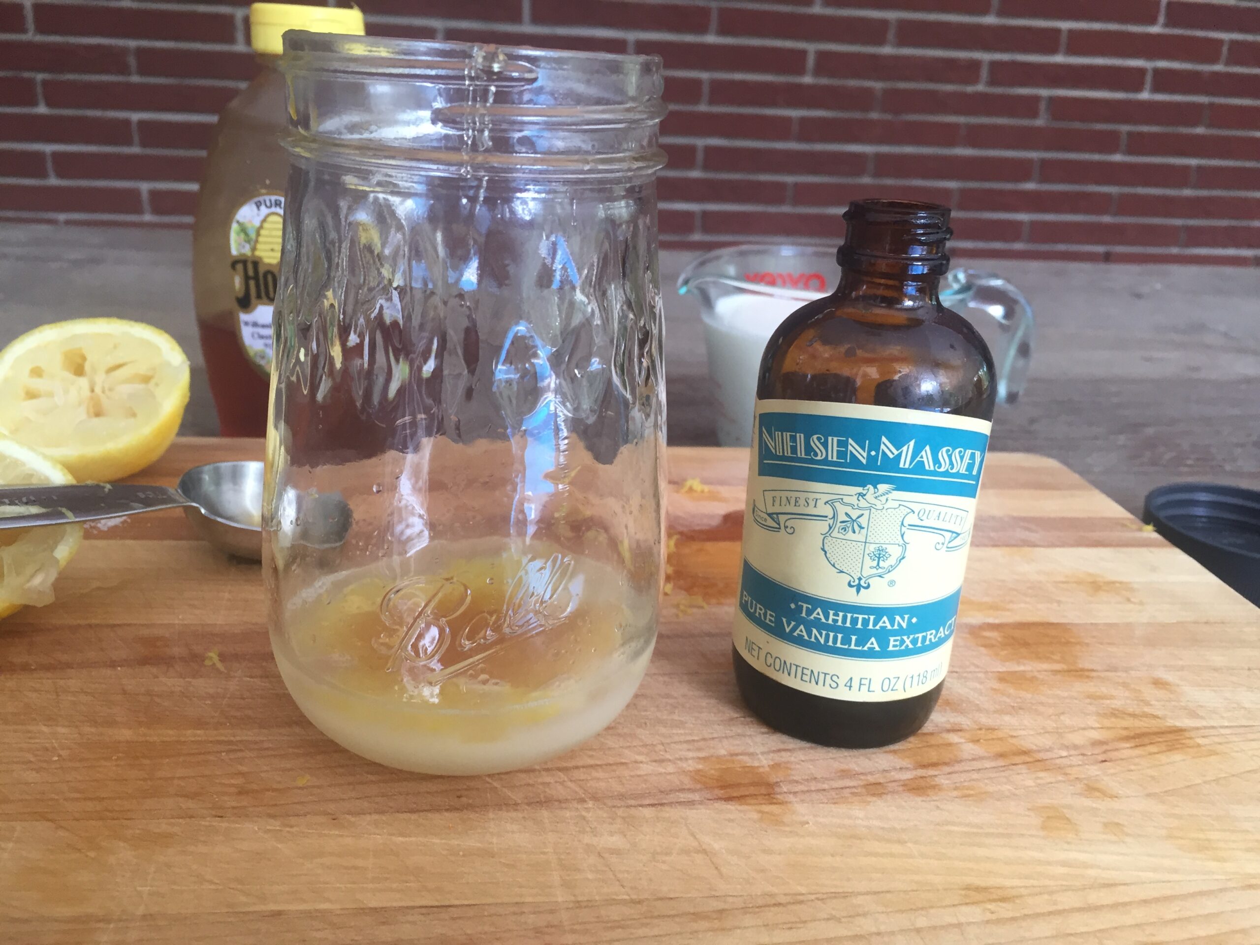 a mason jar with lemon juice and a bottle of vanilla extract